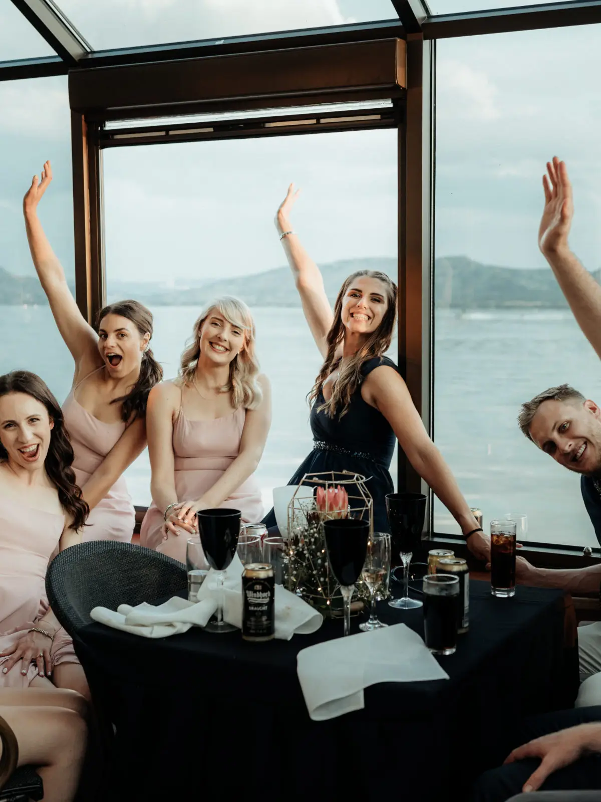 Colleagues raising their arms on deck at a year-end cruise