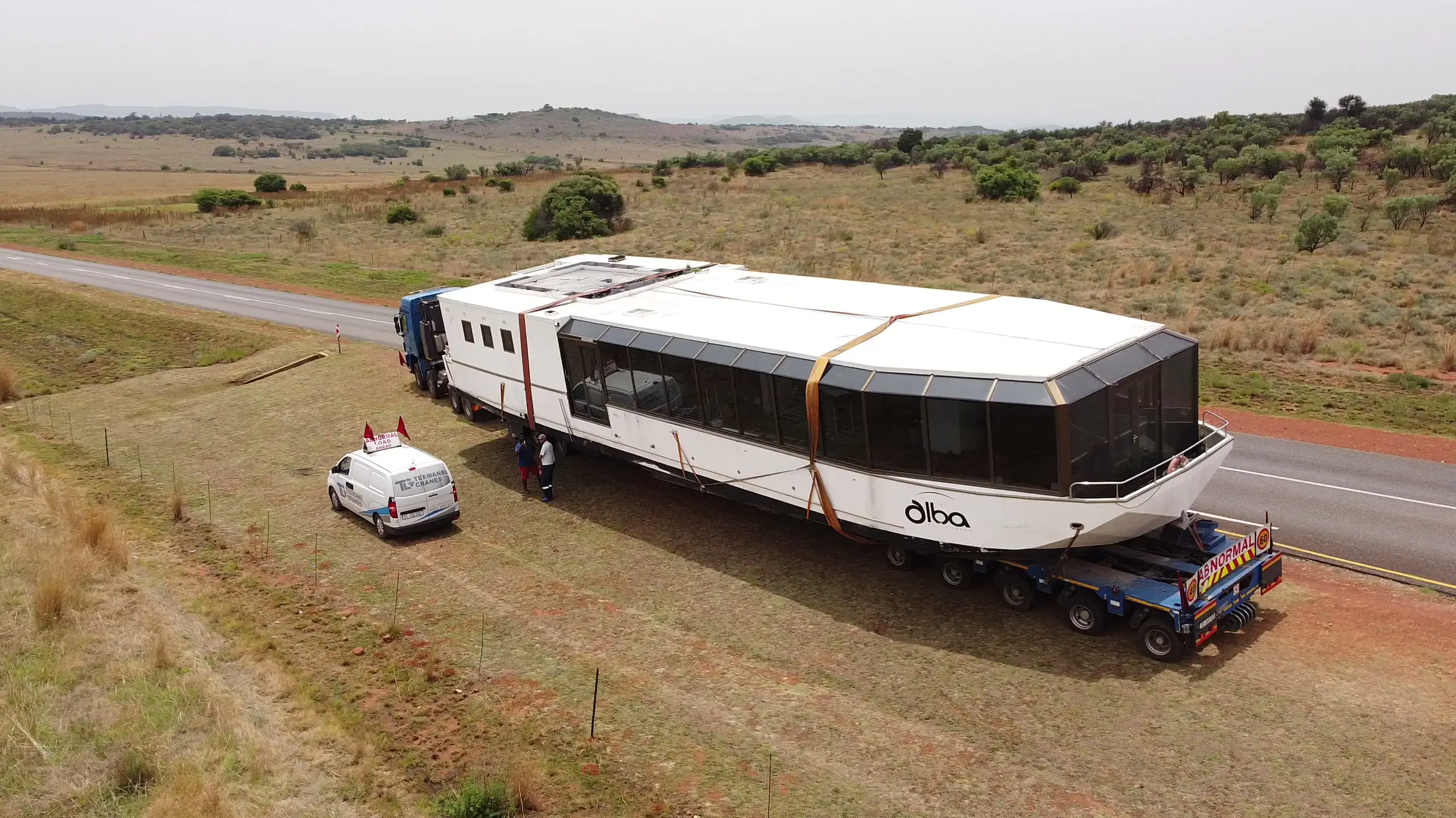 The Alba on a low-bed truck on an empty highveld road