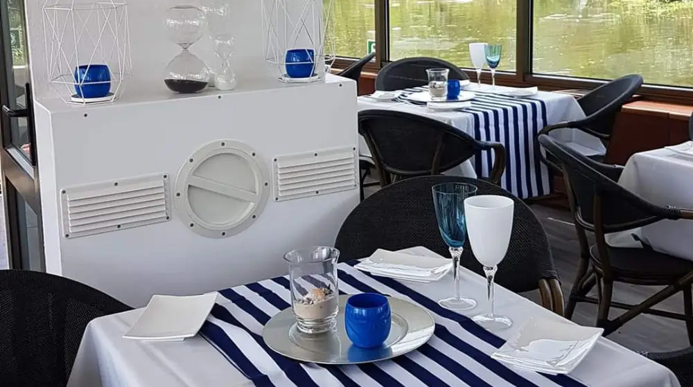 A table laid with striped runners and blue glass