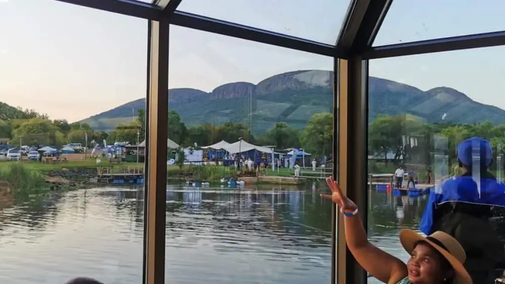 Guests at a window table looking out at the Magaliesberg